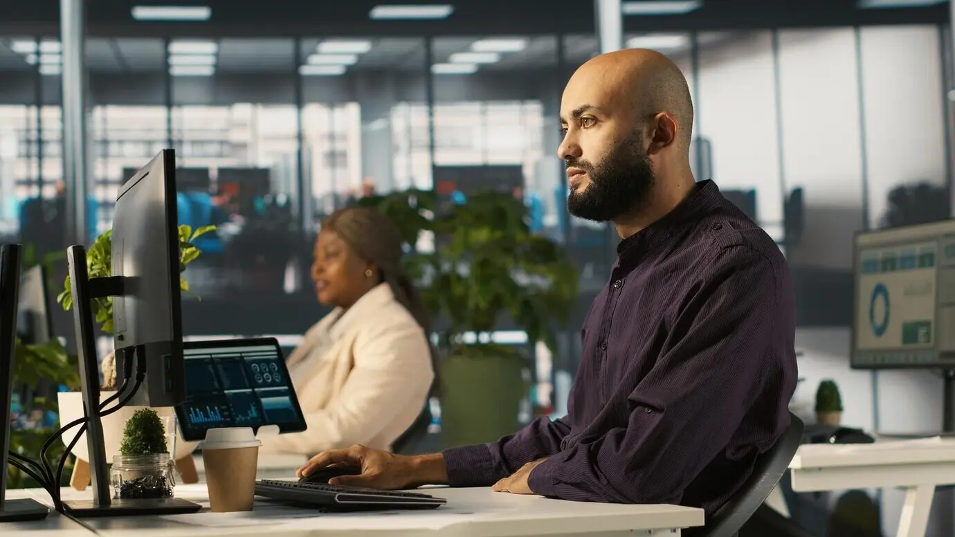Mann im Büro, der Finanzdiagramme überprüft und KPIs analysiert.